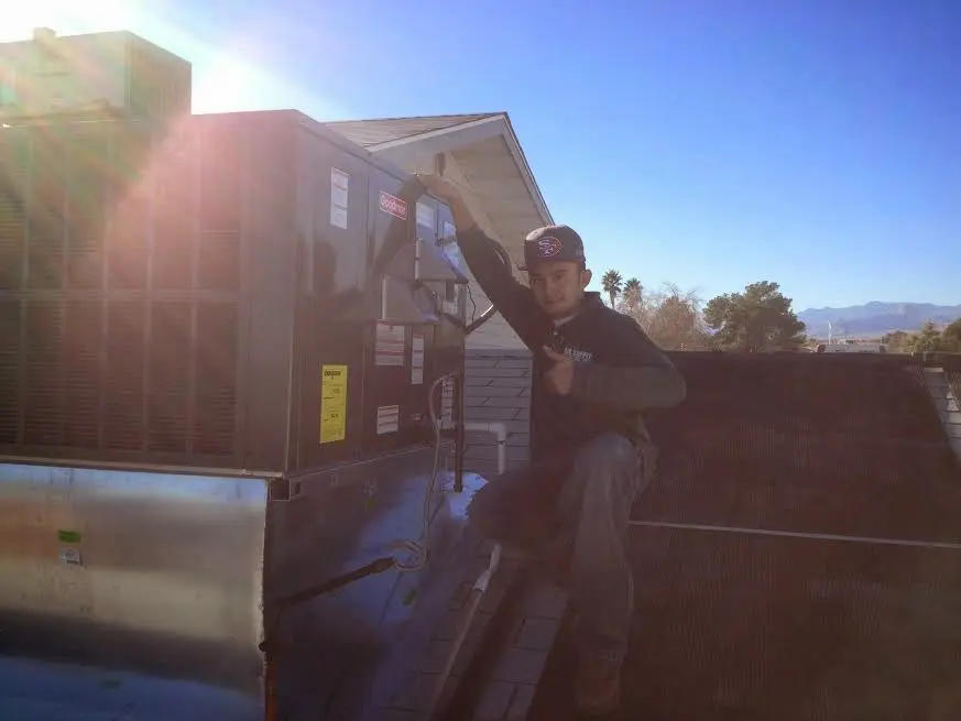 HVAC technician performing AC Tune-Up on a rooftop unit in Fond du Lac